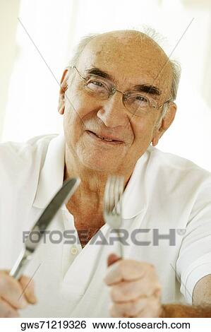 Portrait of a senior man holding a fork and a table knife View Large Photo Image Stock Photograph - Portrait of a senior man holding a fork and a table knife. Fotosearch