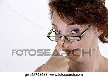 Stock Photo - Portrait of a senior woman adjusting her eyeglasses. Fotosearch