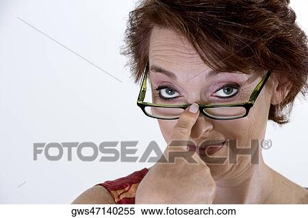 Stock Photography - Portrait of a senior woman adjusting her eyeglasses. Fotosearch