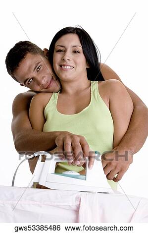 Portrait of a young couple ironing on an ironing board View Large Photo Image Stock Photograph - Portrait of a young couple ironing on an ironing board. Fotosearch