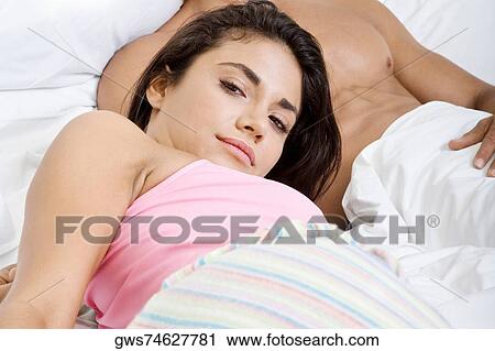 Portrait of a young couple lying on the bed View Large Photo Image Stock Image - Portrait of a young couple lying on the bed. Fotosearch