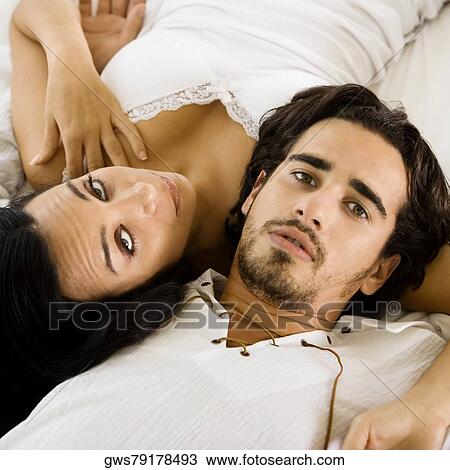 Portrait of a young couple lying on the bed View Large Photo Image Stock Image - Portrait of a young couple lying on the bed. Fotosearch