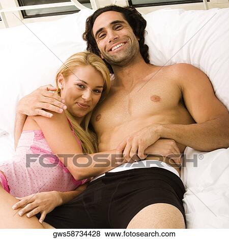 Portrait of a young couple lying on the bed View Large Photo Image Stock Photo - Portrait of a young couple lying on the bed. Fotosearch