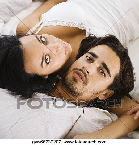 Portrait of a young couple lying on the bed View Large Photo Image Stock Photo - Portrait of a young couple lying on the bed. Fotosearch