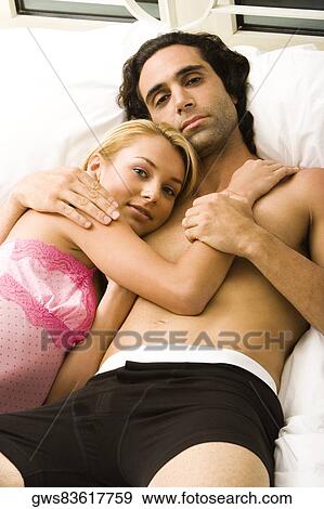 Portrait of a young couple lying on the bed View Large Photo Image Stock Photo - Portrait of a young couple lying on the bed. Fotosearch