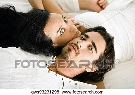 Portrait of a young couple lying on the bed View Large Photo Image Stock Photo - Portrait of a young couple lying on the bed. Fotosearch