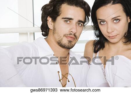 Portrait of a young couple sitting side by side View Large Photo Image Stock Image - Portrait of a young couple sitting side by side. Fotosearch