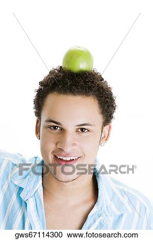 Portrait of a young man balancing a green apple on his head View Large Photo Image Stock Image - Portrait of a young man balancing a green apple on his head. Fotosearch