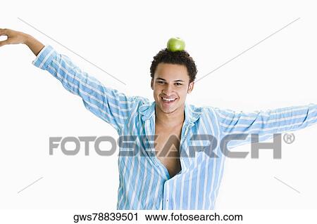 Portrait of a young man balancing a green apple on his head View Large Photo Image Stock Image - Portrait of a young man balancing a green apple on his head. Fotosearch