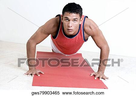 Portrait of a young man doing push-ups on an exercise mat View Large Photo Image Stock Photography - Portrait of a young man doing push-ups on an exercise mat. Fotosearch