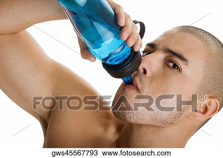 Stock Image - Portrait of a young man drinking water from a bottle. Fotosearch