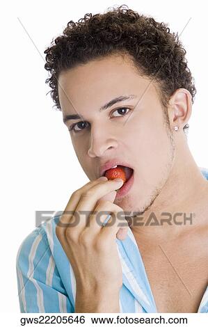 Portrait of a young man eating a strawberry View Large Photo Image Stock Photograph - Portrait of a young man eating a strawberry. Fotosearch