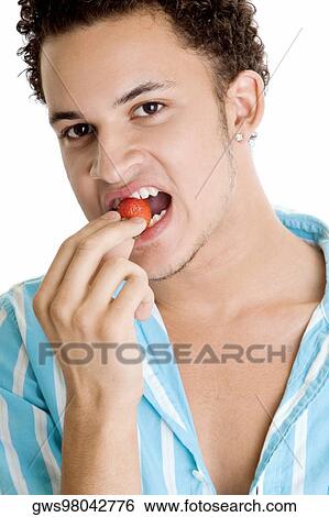 Portrait of a young man eating a strawberry View Large Photo Image Stock Photograph - Portrait of a young man eating a strawberry. Fotosearch