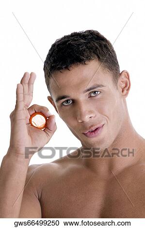 Portrait of a young man holding a condom View Large Photo Image Stock Image - Portrait of a young man holding a condom. Fotosearch