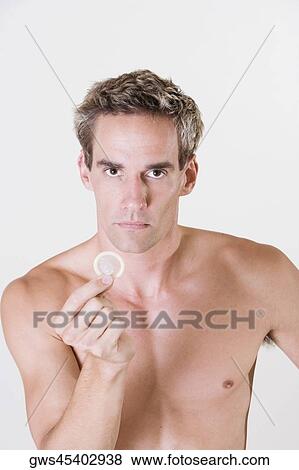 Portrait of a young man holding a condom View Large Photo Image Stock Photo - Portrait of a young man holding a condom. Fotosearch