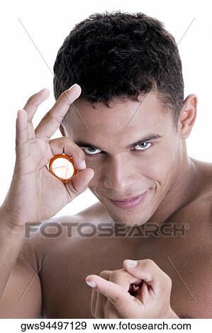 Portrait of a young man holding a condom View Large Photo Image Stock Photo - Portrait of a young man holding a condom. Fotosearch