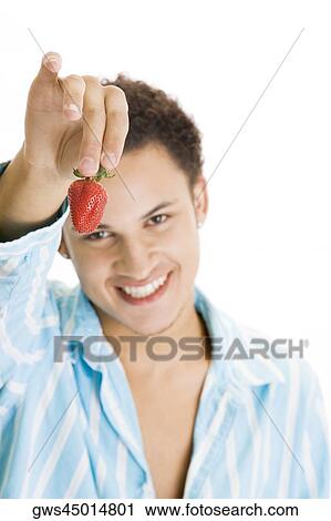 Portrait of a young man holding a strawberry View Large Photo Image Stock Image - Portrait of a young man holding a strawberry. Fotosearch