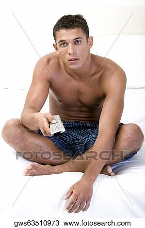 Portrait of a young man holding a remote control View Large Photo Image Stock Image - Portrait of a young man holding a remote control. Fotosearch