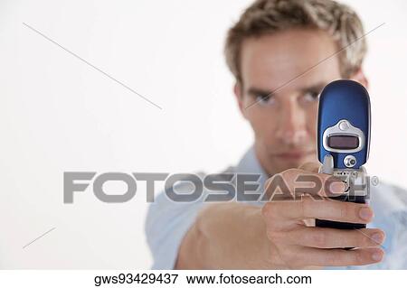 Portrait of a young man holding a mobile phone View Large Photo Image Stock Photo - Portrait of a young man holding a mobile phone. Fotosearch
