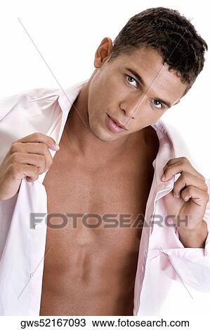 Stock Image - Portrait of a young man holding his shirt. Fotosearch