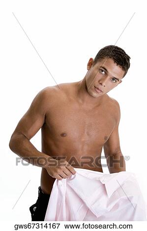 Portrait of a young man holding his shirt View Large Photo Image Stock Photo - Portrait of a young man holding his shirt. Fotosearch