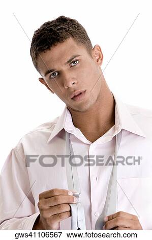Portrait of a young man holding his tie View Large Photo Image Stock Photo - Portrait of a young man holding his tie. Fotosearch