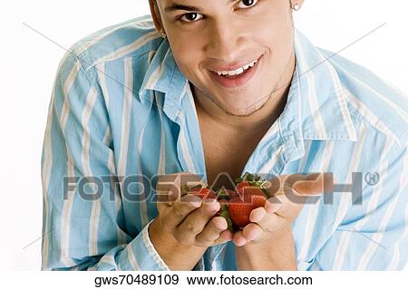 Portrait of a young man holding strawberries View Large Photo Image Stock Photo - Portrait of a young man holding strawberries. Fotosearch