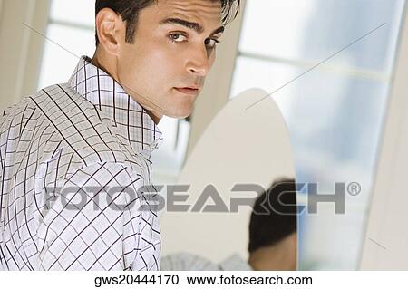 Portrait of a young man in front of a mirror View Large Photo Image Stock Image - Portrait of a young man in front of a mirror. Fotosearch