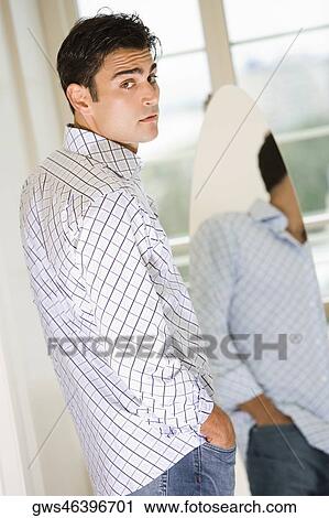 Portrait of a young man in front of a mirror View Large Photo Image Stock Image - Portrait of a young man in front of a mirror. Fotosearch