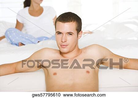 Portrait of a young man leaning against the bed View Large Photo Image Stock Image - Portrait of a young man leaning against the bed. Fotosearch