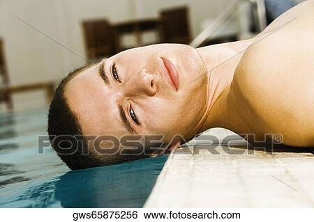 Portrait of a young man lying at the poolside View Large Photo Image Stock Photograph - Portrait of a young man lying at the poolside. Fotosearch