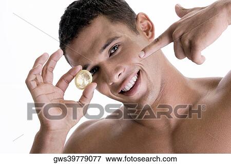 Portrait of a young man pointing to a condom View Large Photo Image Stock Photo - Portrait of a young man pointing to a condom. Fotosearch