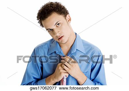 Portrait of a young man pulling his tie View Large Photo Image Stock Photo - Portrait of a young man pulling his tie. Fotosearch