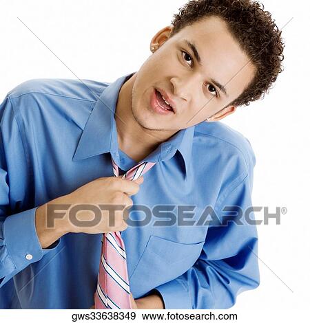 Stock Photo - Portrait of a young man pulling his tie. Fotosearch