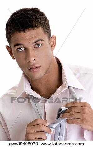Portrait of a young man putting on a tie View Large Photo Image Stock Image - Portrait of a young man putting on a tie. Fotosearch