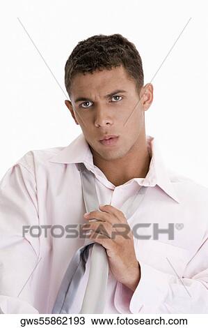 Portrait of a young man putting on a tie View Large Photo Image Stock Image - Portrait of a young man putting on a tie. Fotosearch