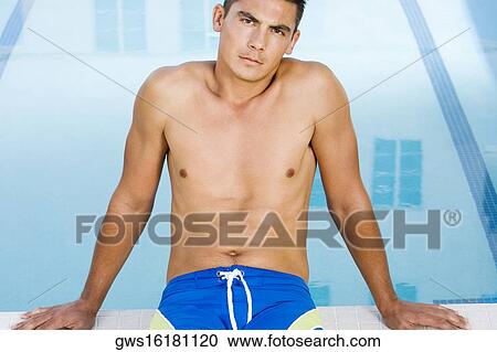 Portrait of a young man sitting at the poolside View Large Photo Image Stock Image - Portrait of a young man sitting at the poolside. Fotosearch