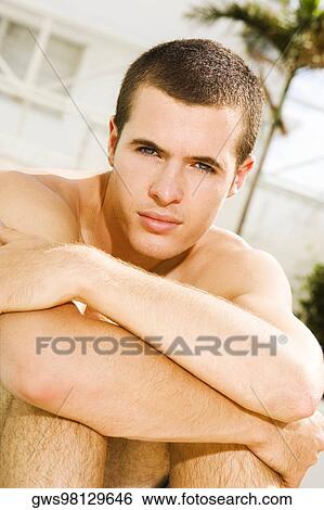 Portrait of a young man sitting at the poolside View Large Photo Image Stock Photograph - Portrait of a young man sitting at the poolside. Fotosearch