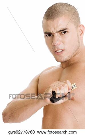 Stock Image - Portrait of a young man squeezing a hand grip. Fotosearch