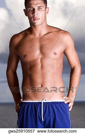 Portrait of a young man standing bare chested on the beach View Large Photo Image Stock Photo - Portrait of a young man standing bare chested on the beach. Fotosearch