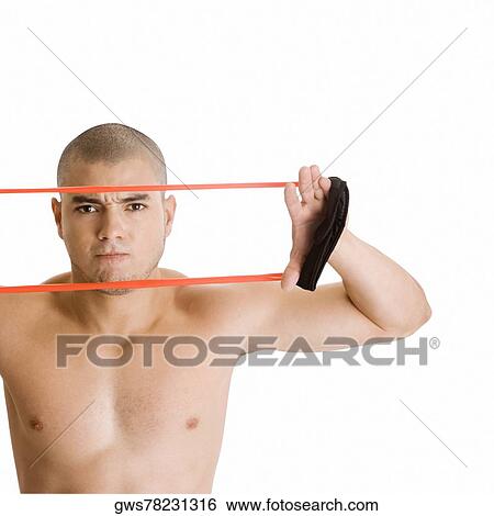 Stock Photograph - Portrait of a young man stretching a resistance band. Fotosearch