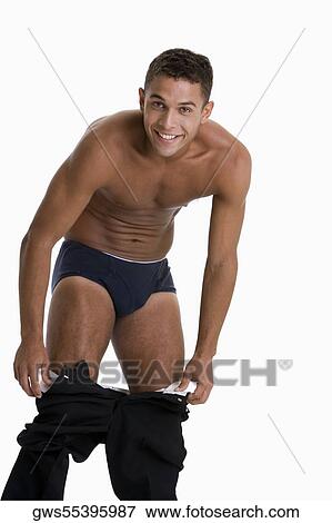 Portrait of a young man taking off his pants View Large Photo Image Stock Photo - Portrait of a young man taking off his pants. Fotosearch