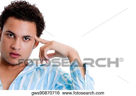Stock Photograph - Portrait of a young man thinking with his finger on his temple. Fotosearch