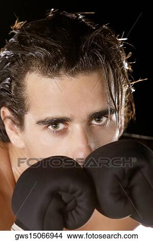 Picture - Portrait of a young man wearing boxing gloves. Fotosearch