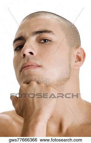 Portrait of a young man with his hand on his chin View Large Photo Image Stock Photograph - Portrait of a young man with his hand on his chin. Fotosearch