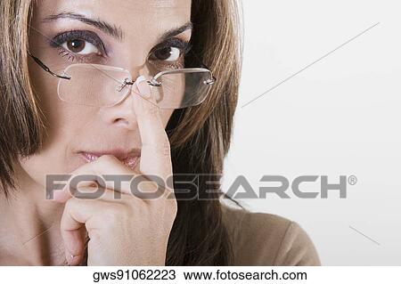 Portrait of a young woman adjusting her eyeglasses View Large Photo Image Stock Image - Portrait of a young woman adjusting her eyeglasses. Fotosearch