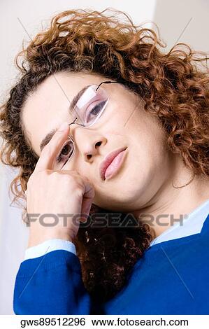 Portrait of a young woman adjusting her eyeglasses View Large Photo Image Stock Photograph - Portrait of a young woman adjusting her eyeglasses. Fotosearch
