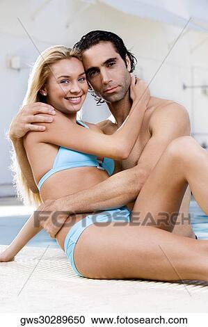 Portrait of a young woman and a mid adult man embracing at the poolside View Large Photo Image Stock Image - Portrait of a young woman and a mid adult man embracing at the poolside. Fotosearch