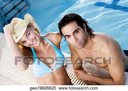 Portrait of a young woman and a mid adult man at the poolside View Large Photo Image Stock Image - Portrait of a young woman and a mid adult man at the poolside. Fotosearch