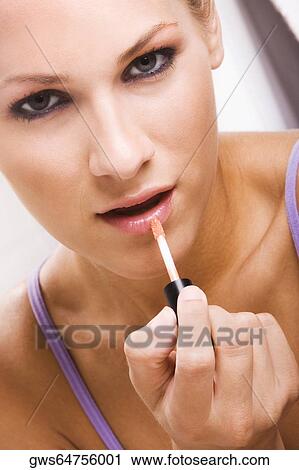 Portrait of a young woman applying lip liner View Large Photo Image Stock Image - Portrait of a young woman applying lip liner. Fotosearch